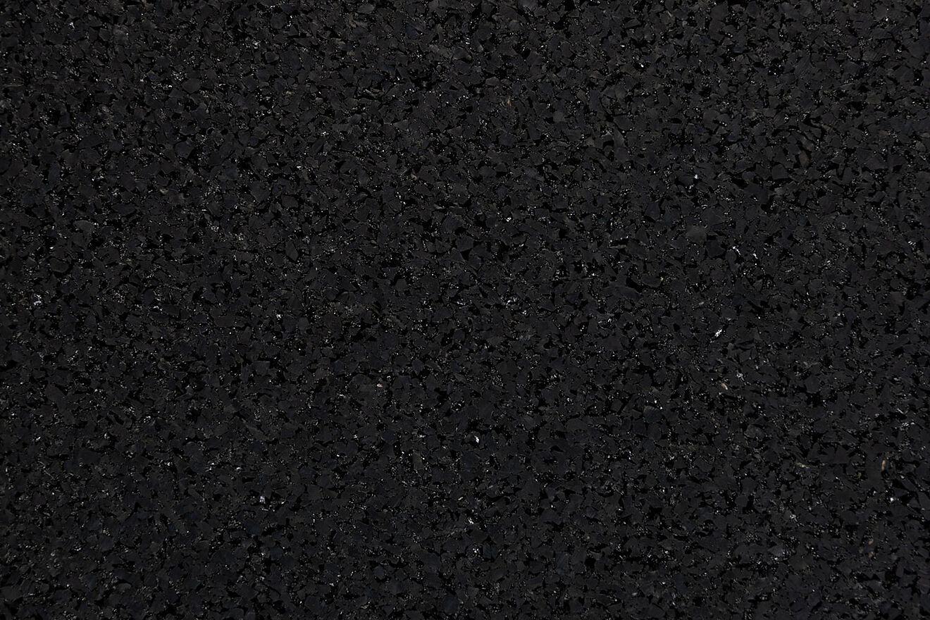 Detailed view of REGUPOL resist fire's granulate structure, showcasing Close-up of REGUPOL resist fire's granulate structure – recycled rubber granules with flame-retardant properties.