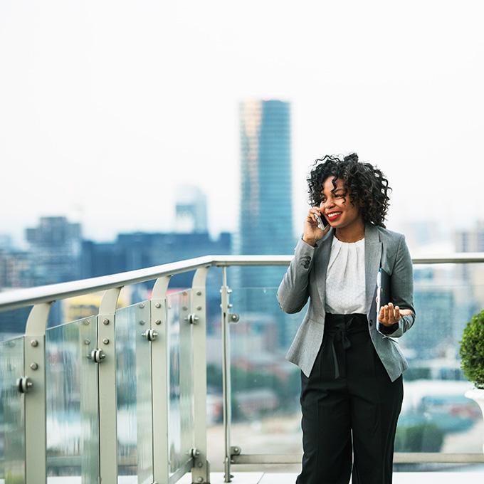 Woman standing on a roof terrace and talking on the phone